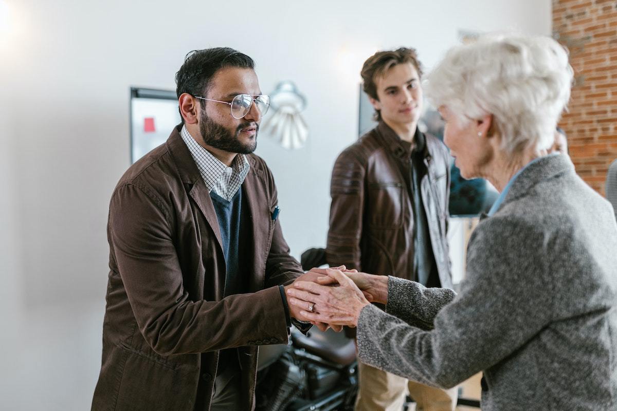 pessoas conversando e duas delas estão apertando as mãos