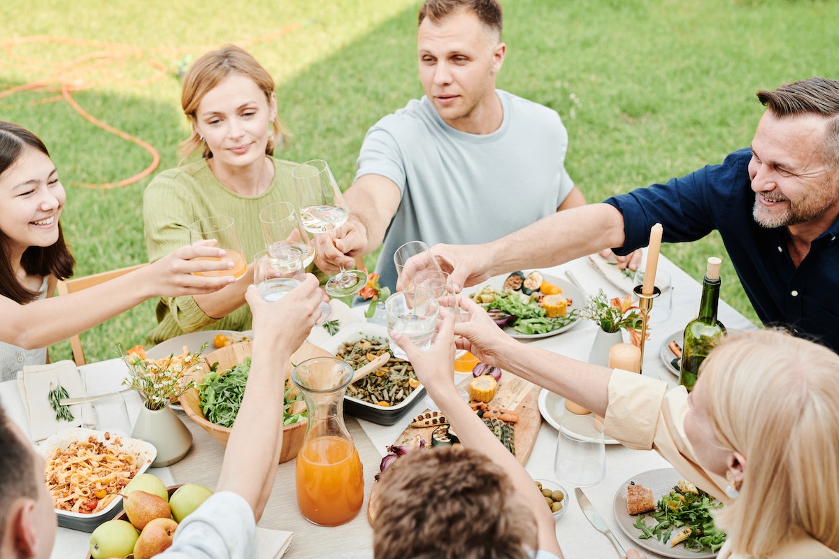 Pessoas na mesa de almoço: Comunicação assertiva Comunicação assertiva: A imagem mostra uma família almoçando