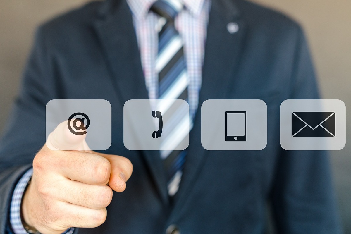 Homem e símbolos na tela: Pós venda Pós - venda: A imagem mostra um homem estilo executivo, e sobre a imagem alguns símbolos, como o arroba, telefone, celular e também e - mail.