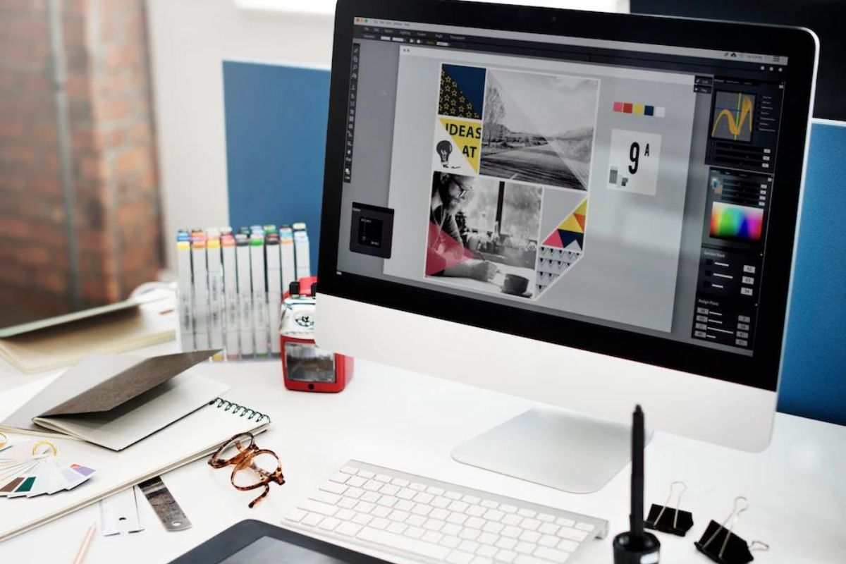 Mesa de trabalho de um designer: Publicidade e design gráfico Publicidade e design gráfico: A imagem mostra uma pessoa de trabalho de um profissional de design, onde está o um computador com uma arte criada