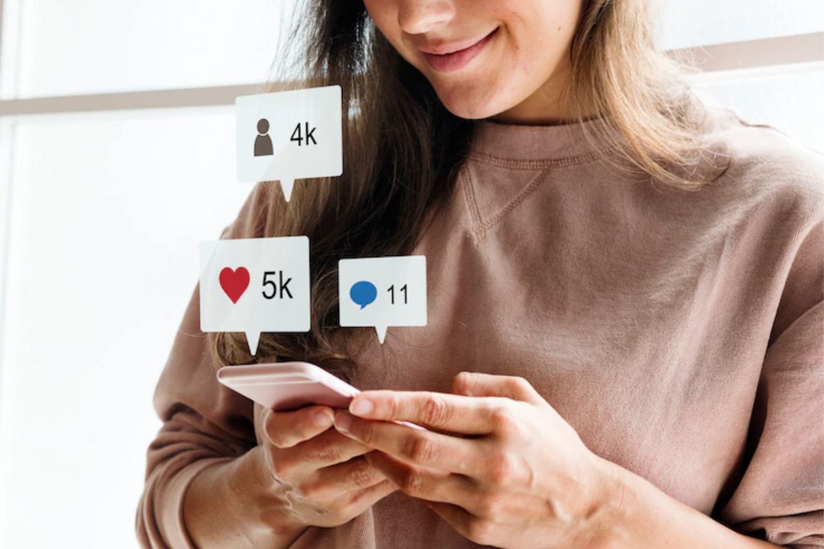 mulher usando celular: roi das mídias sociais mulher usando celular