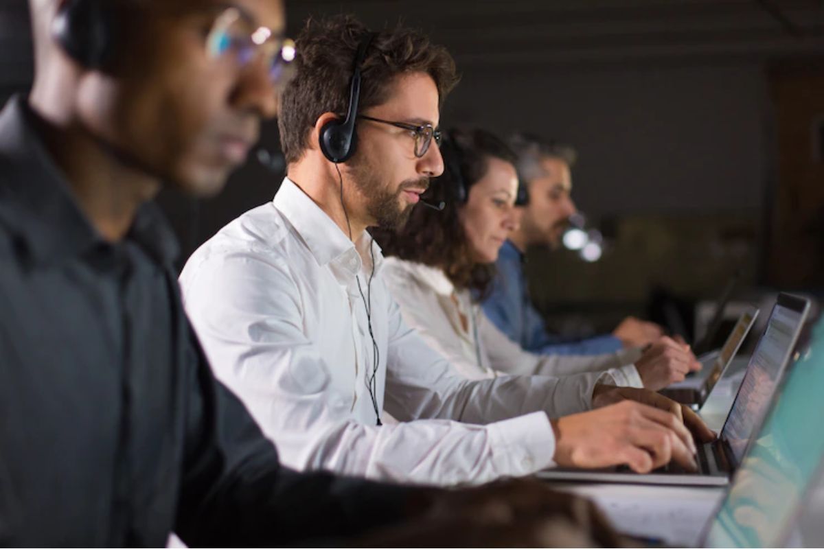 pessoas trabalhando: suporte ao cliente pessoas trabalhando em fileira, cada uma no seu laptop