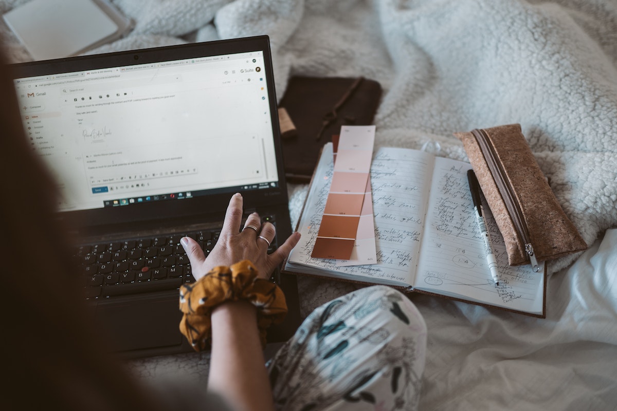 Mulher usando o computador: URL Builder URL Builder: a imagem mostra uma mulher usando o computador para enviar um e-mail, ao lado dela estão algumas anotações.