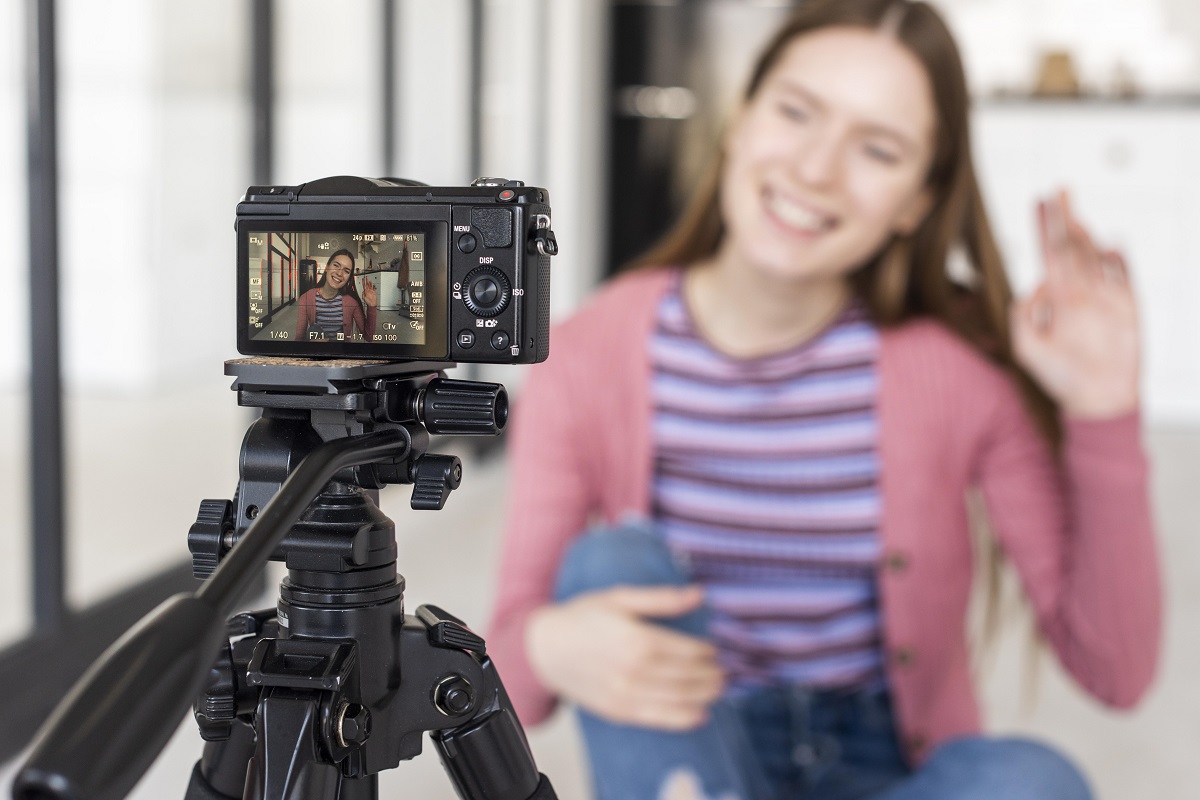 Vídeos para redes sociais: a imagem mostra uma mulher jovem gravando um vídeo em sua gravadora. 