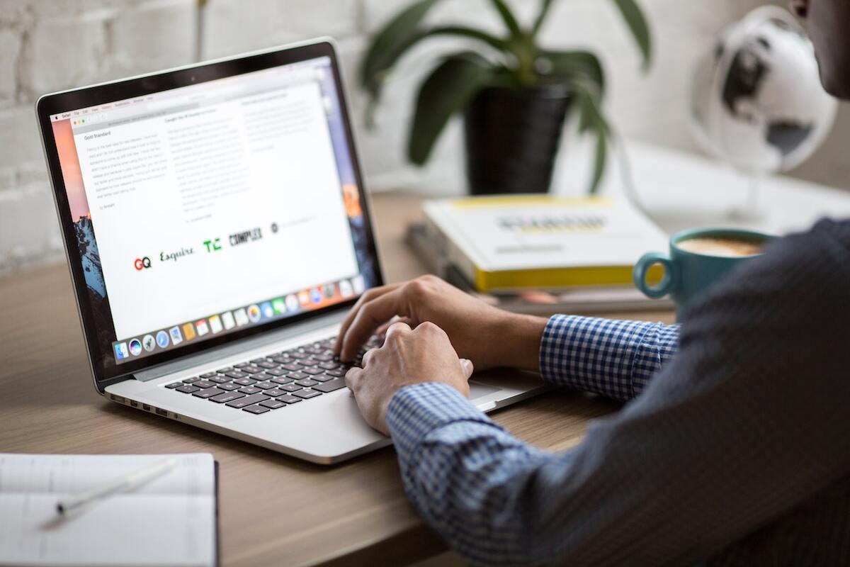 Notebook: Atrair clientes Homem usando notebook para analisar conteúdos e bolar planos para Atrair clientes