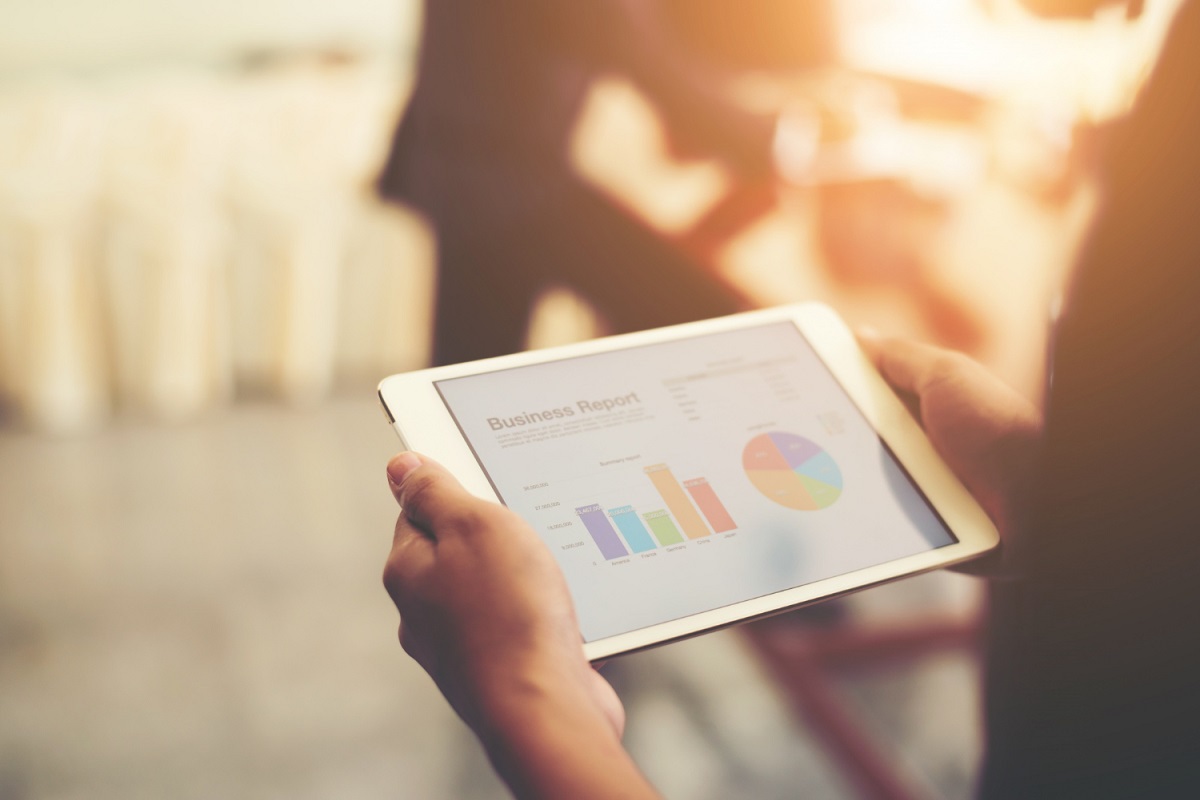 Gráficos: Especialista em marketing digital Pessoa Especialista em marketing digital segurando tablet branco e analisando gráficos na tela do mesmo