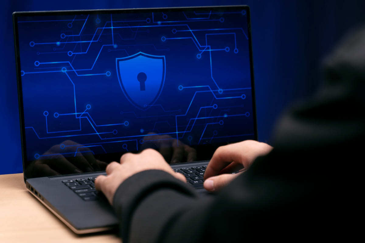 Notebook: Extensões Google Chrome Extensões Google Chrome com bloqueio de tela enquanto pessoa usa notebook sobre mesa de madeira