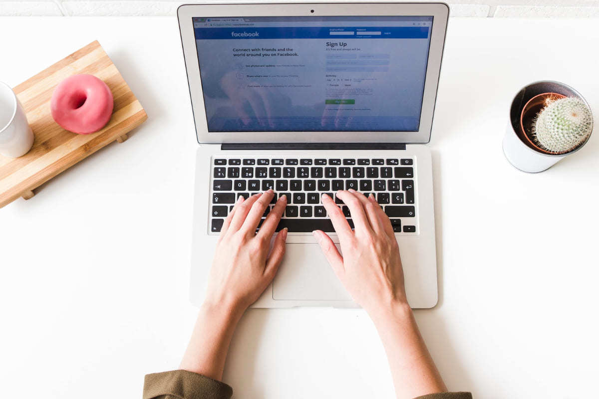 Facebook: Extensões Google Chrome Pessoa usando notebook enquanto este mostra tela de login do Facebook com Extensões Google Chrome
