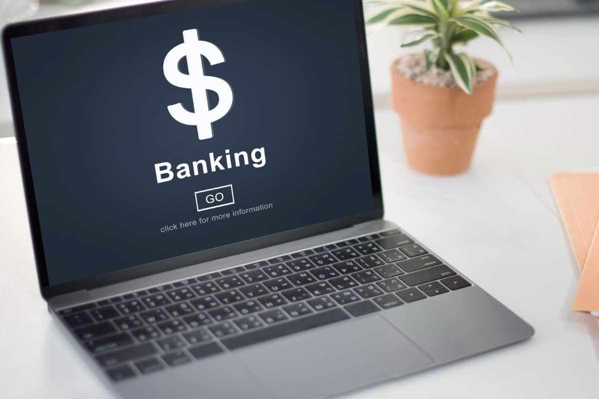 Notebook com internet  banking aberto em sua tela sobre superfície branca