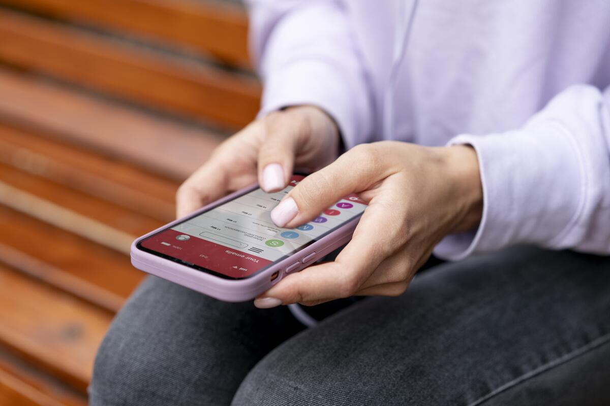 Mulher sentada usando smartphone para Marketing de conteúdo para Saas