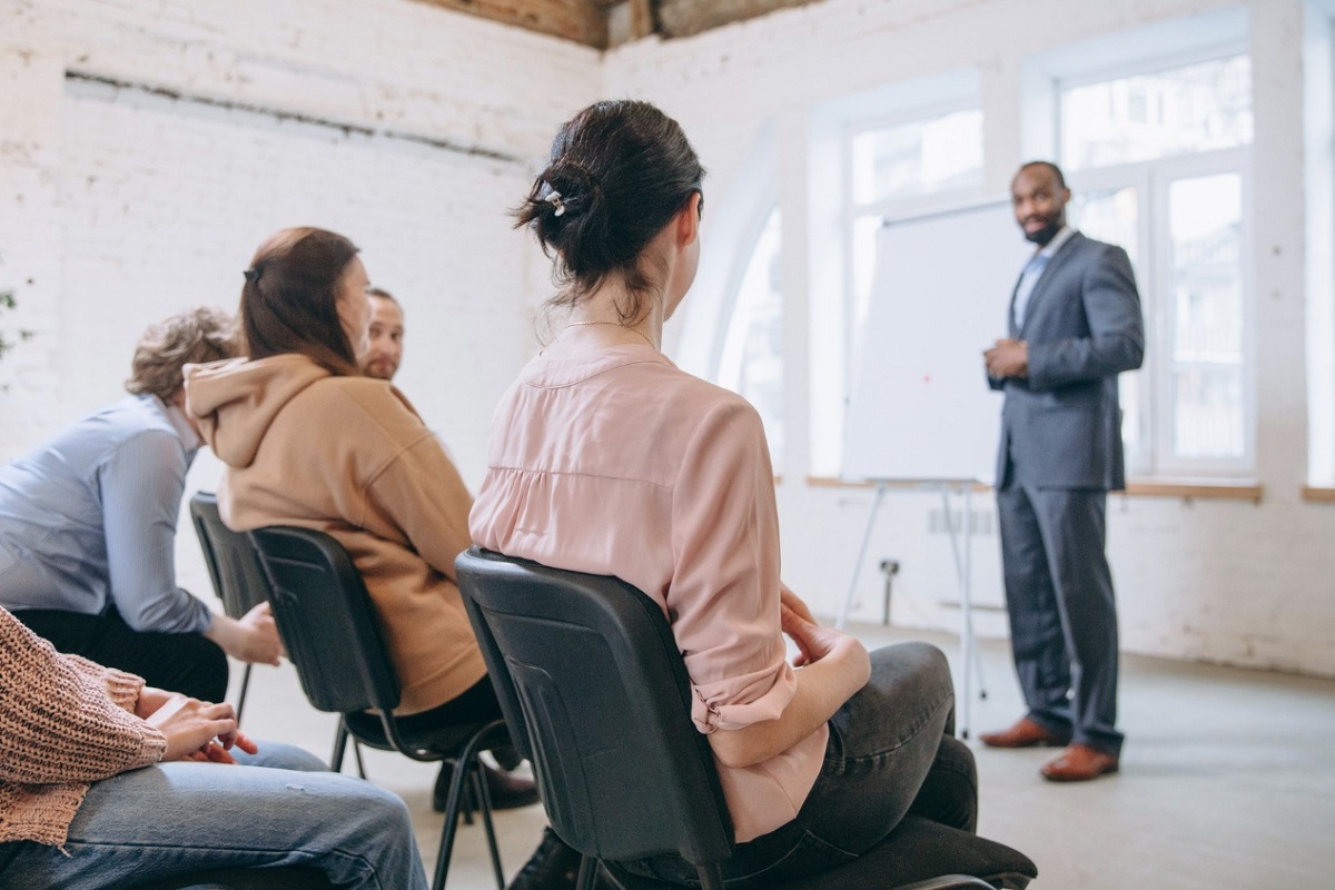 Local de trabalho: Oratória Homem em palestra sobre Oratória diante de colegas de pessoas em local de trabalho