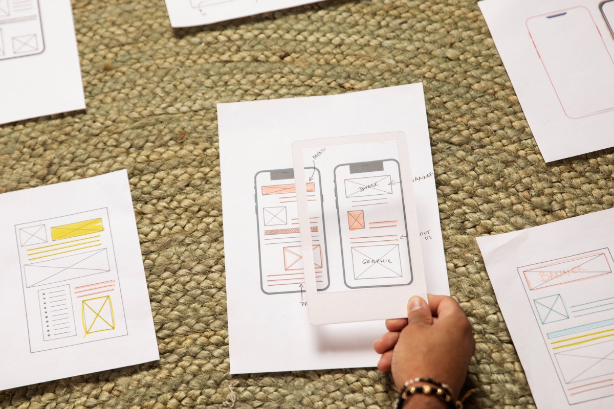 Layout: Práticas de usabilidade do site Pessoa analisando layouts de página impressos em folhas a4