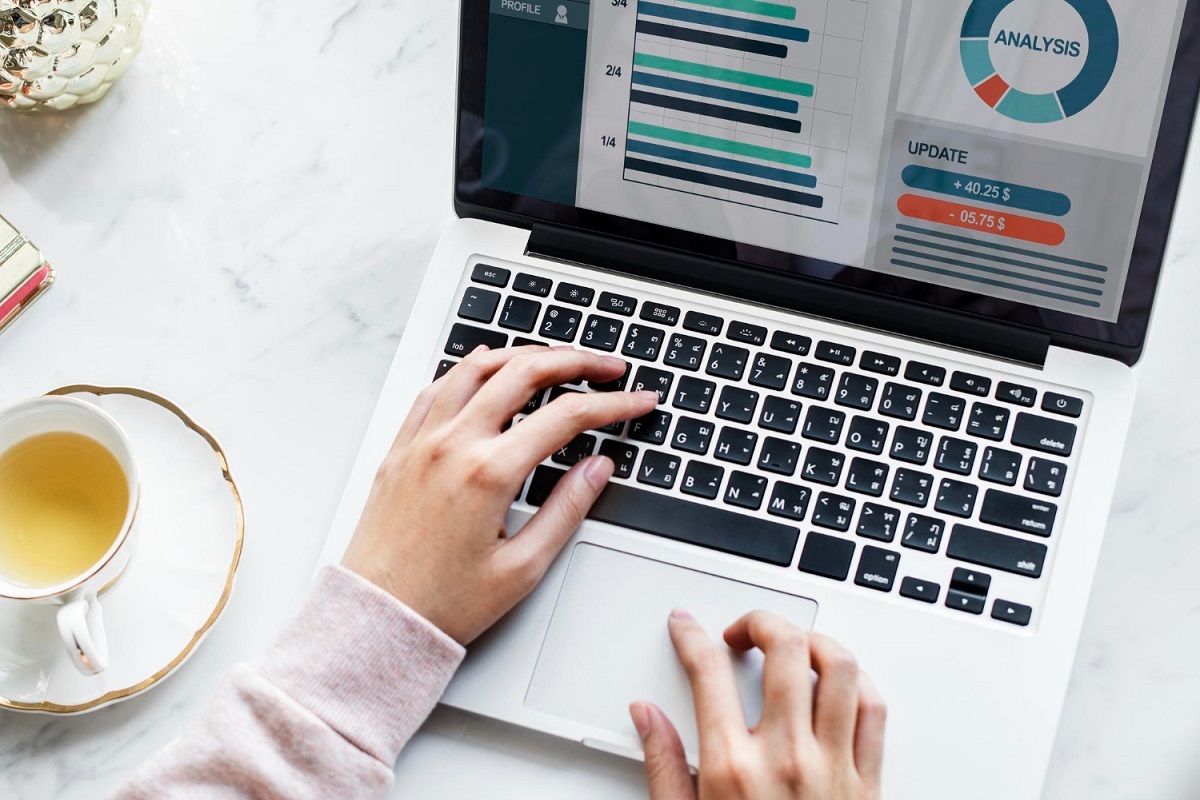 Home office: SEO internacional Pessoa usando notebook em Home office analisando dados de marketing ao lado de xícara de chá branca