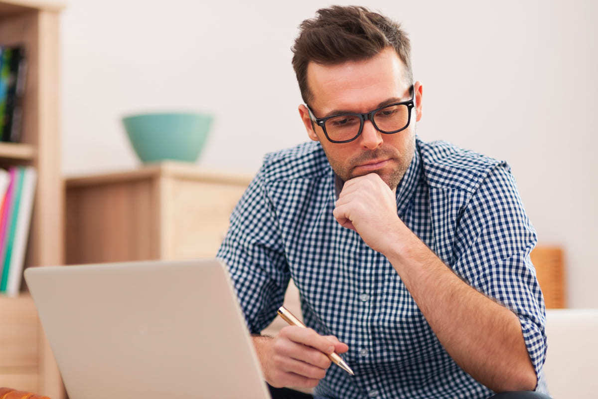 Home office: Teste A/B para e-commerce Homem trabalhando em home office com notebook analisando dados e fazendo Teste A/B para e-commerce com móveis de madeira ao fundo