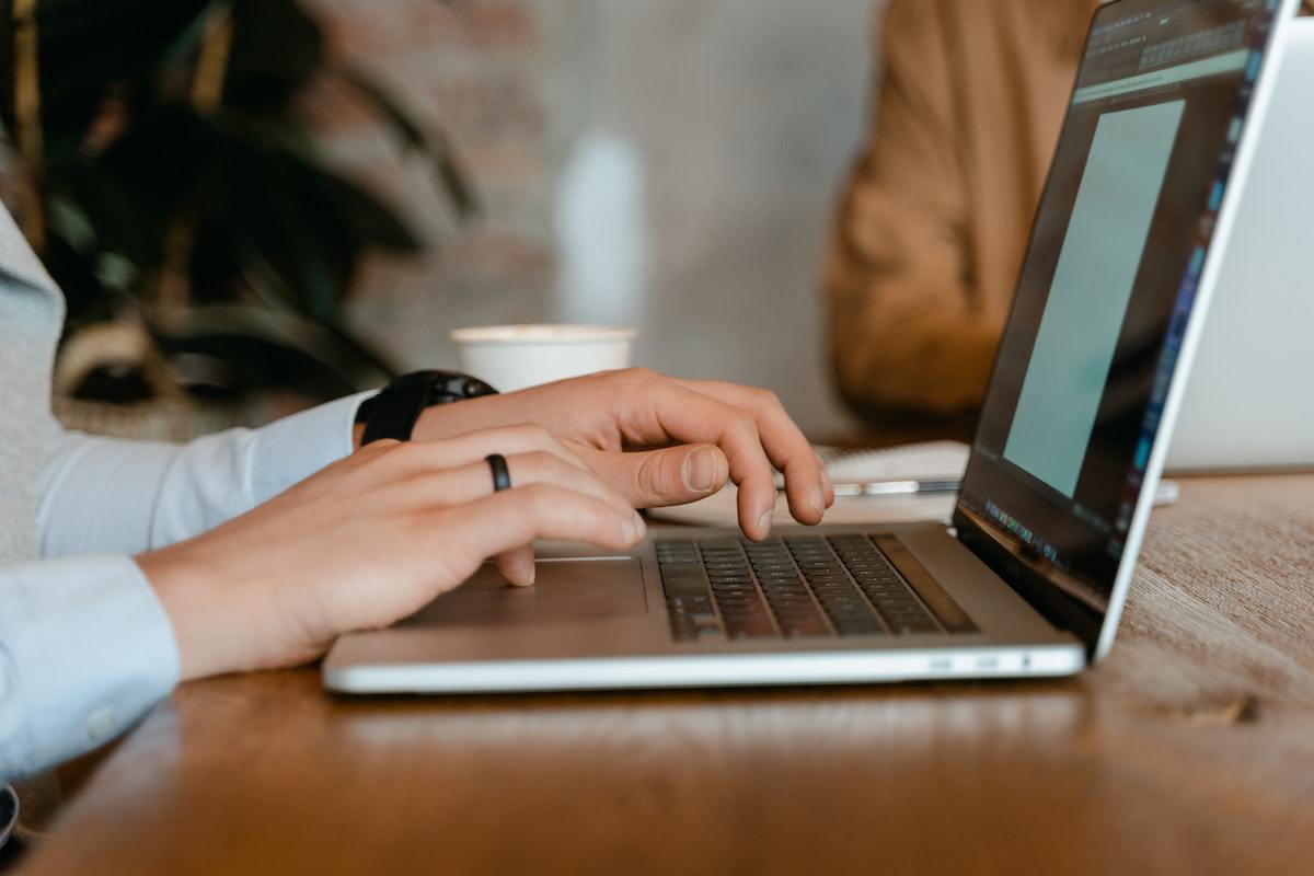 Mulher usando notebook sobre mesa de madeira em home office