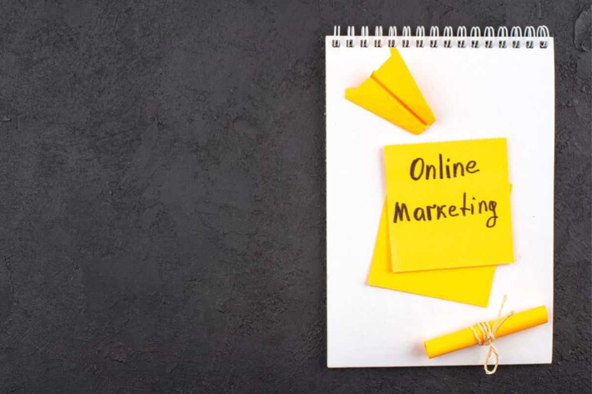 Marketing: White paper White paper representado em montagem com post-it escrito Online Marketing colado em caderno de desenho sobre superfície cinza