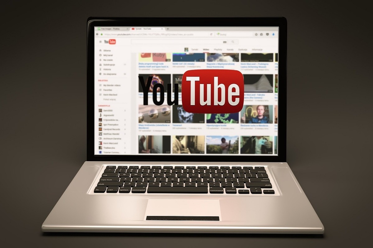 Home page do YouTube em notebook diante de fundo cinza dégradé em montagem gráfica com foto