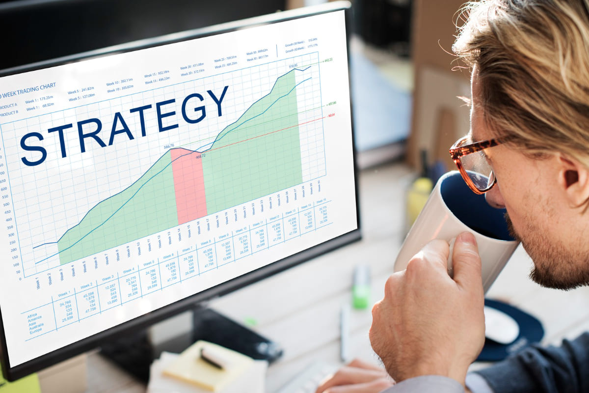 Marketing de escassez: como usar essa estratégia para aumentar as vendas? marketing de escassez: a imagem mostra um homem bebendo café enquanto confere suas estratégias no computador.