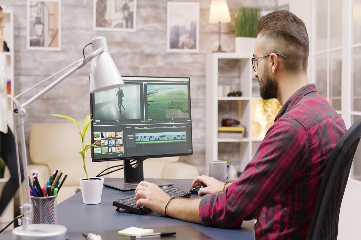 Homem usando Adobe SpeedGrade em computador para fazer edição de arquivos