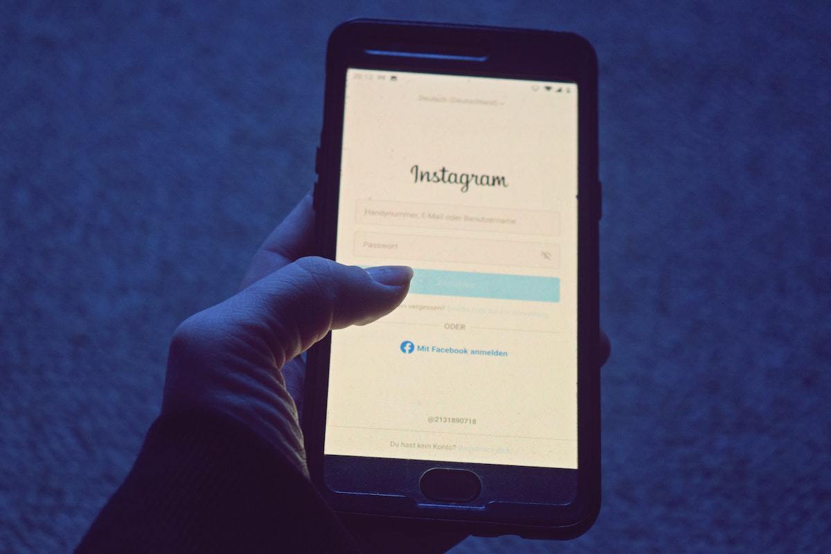 Pessoa segura smartphone com mão esquerda enquanto abre tela de login de rede social no aplicativo do Instagram