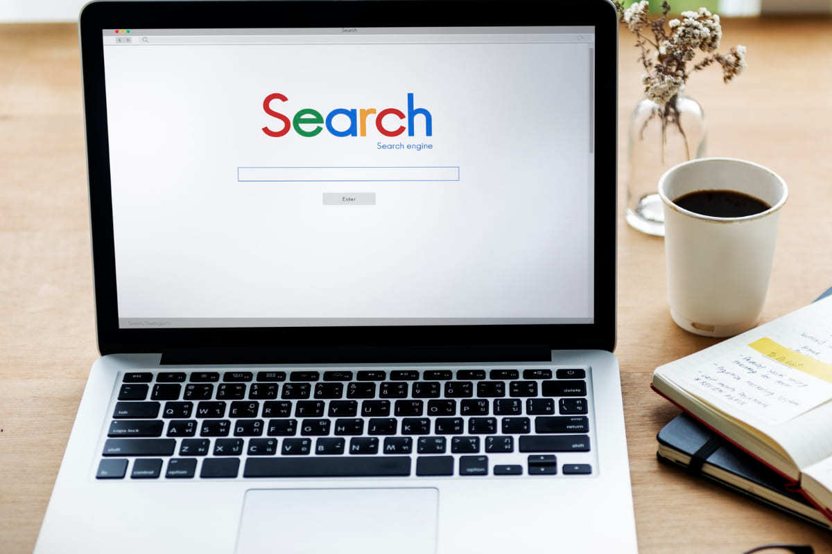 Google: Crawl budget Notebook sobre mesa de madeira com tela inicial da pesquisa Google aberta no mesmo representando tela Crawl budget