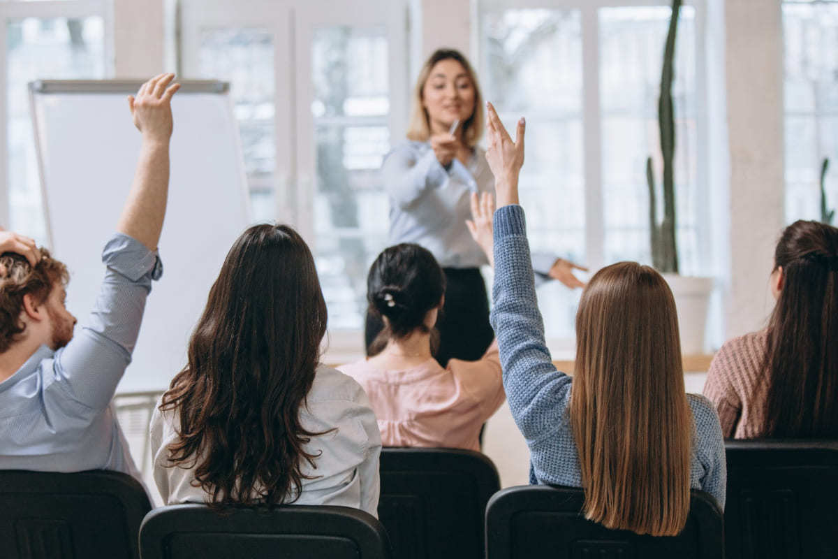 Líder: Demonstração de produto Reunião em local de trabalho com mulher liderando e pedindo opinião dos colegas que erguem braço diante da mesma