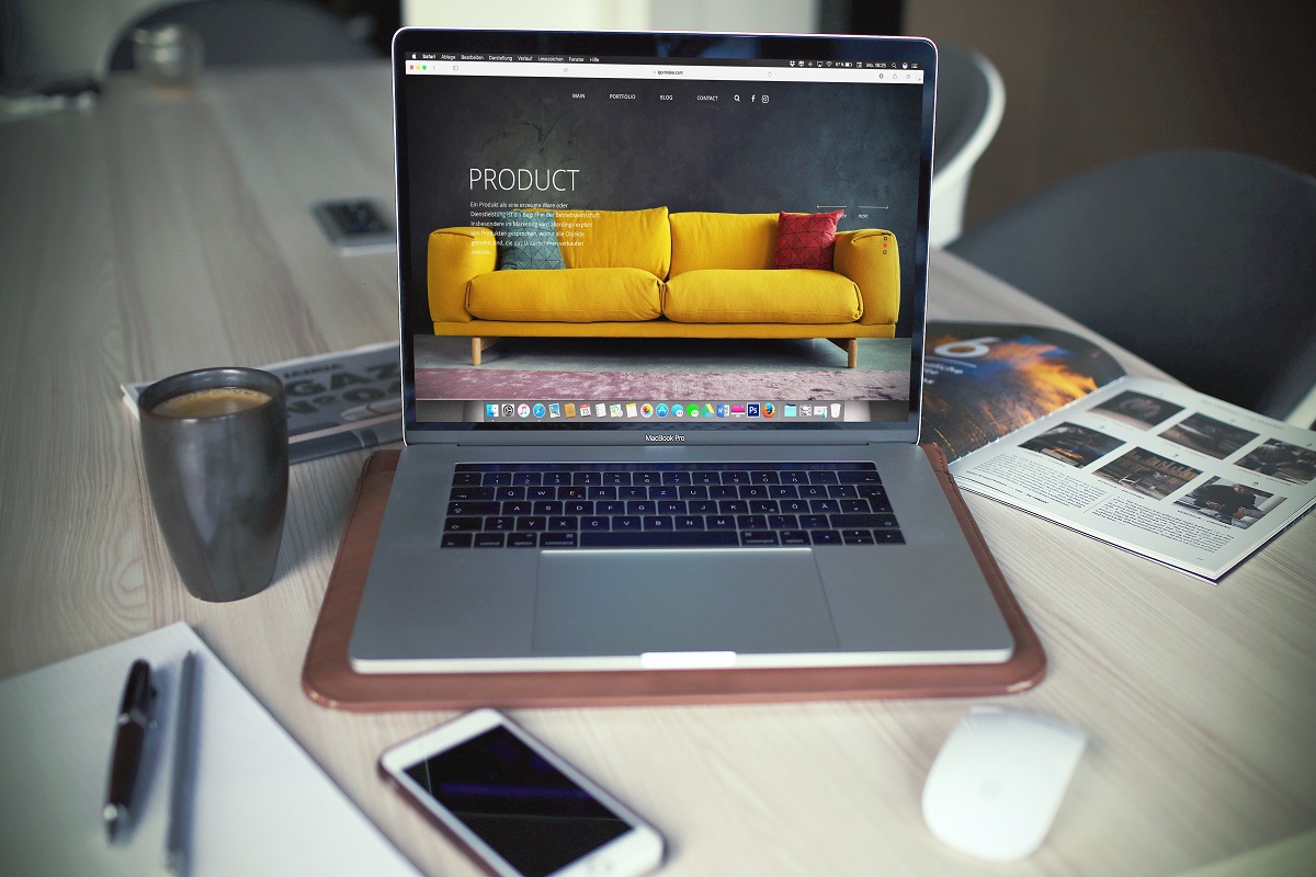 Notebook sobre mesa de madeira em home office ao lado de acessórios e celular em trabalho com Drupal