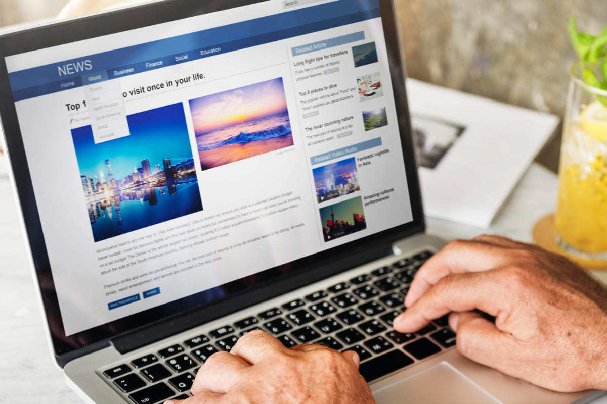 Site: Embed code Pessoa lendo notícias em site usando notebook sobre mesa pequena na cor branca