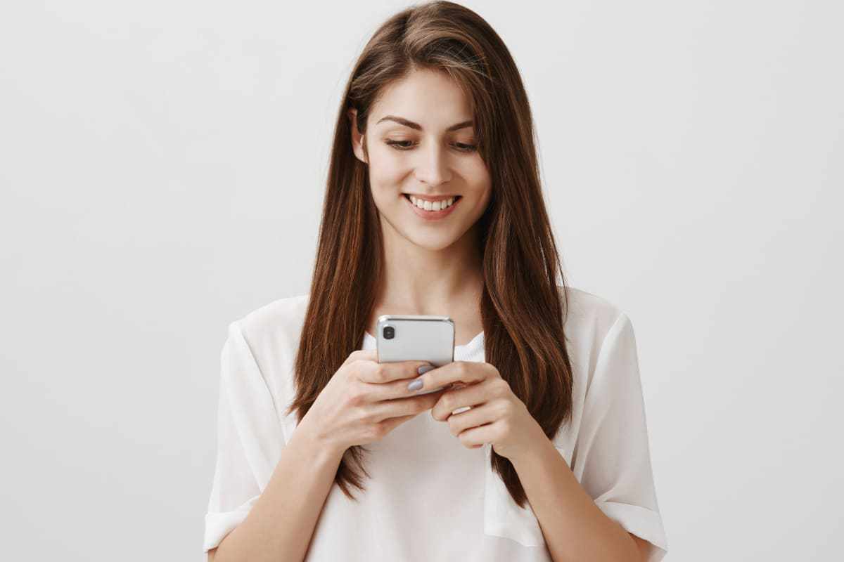 Celular: Ferramentas para criar GIFs Mulher com celular na mão usando Ferramentas para criar GIFs