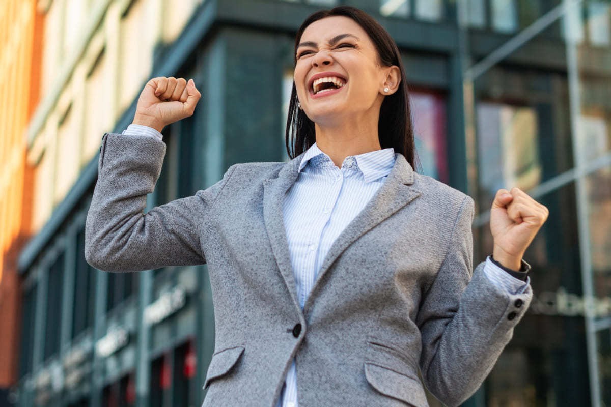 Animação: Fusão de empresas Mulher comemorando em rua após Fusão de empresas com braços erguidos mostrando animação e sorridente
