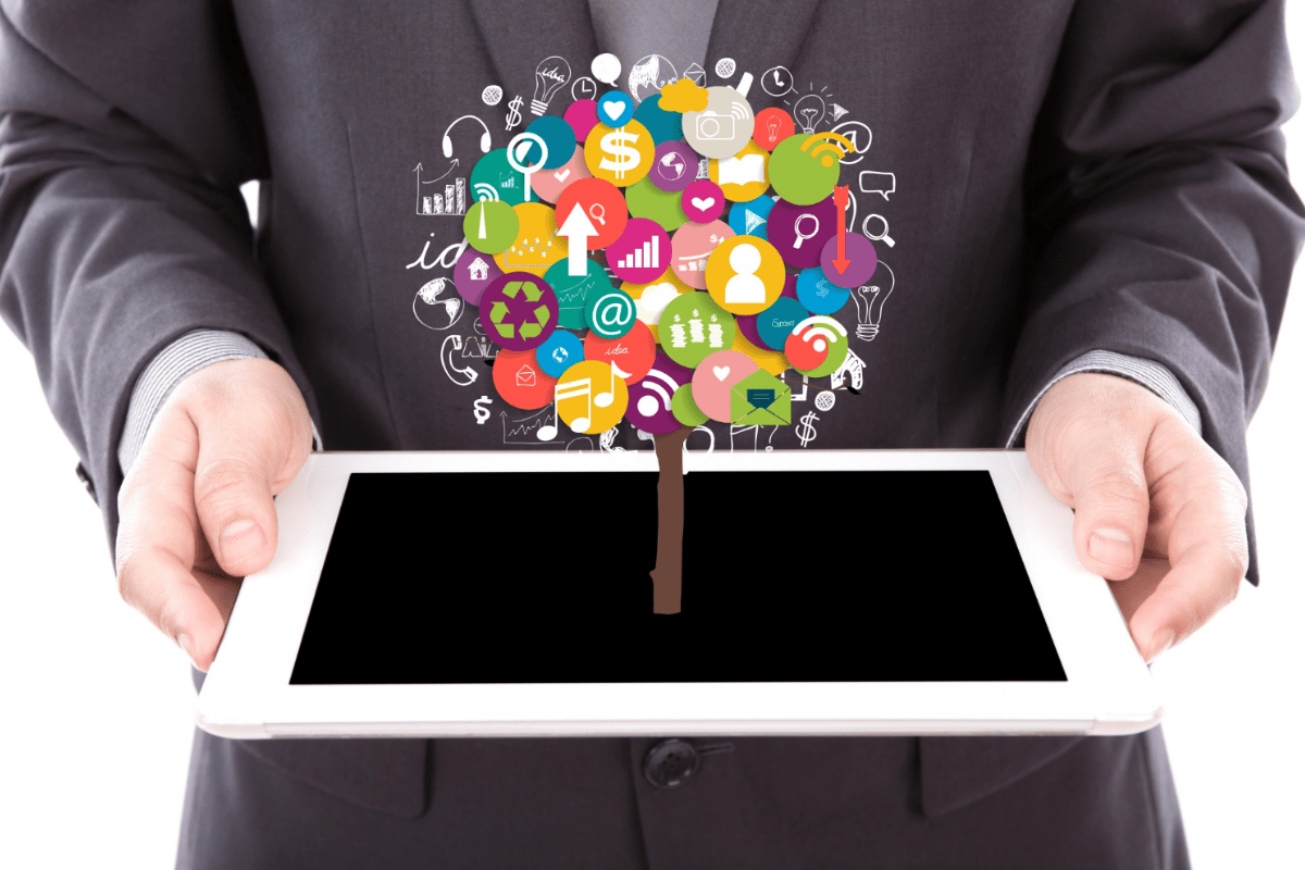 Internet: Go Daddy Pessoa de terno preto segurando tablet como se fosse bandeja com sua tela pra cima e representação holográfica com vários símbolos presentes na internet como se saíssem de sua tela