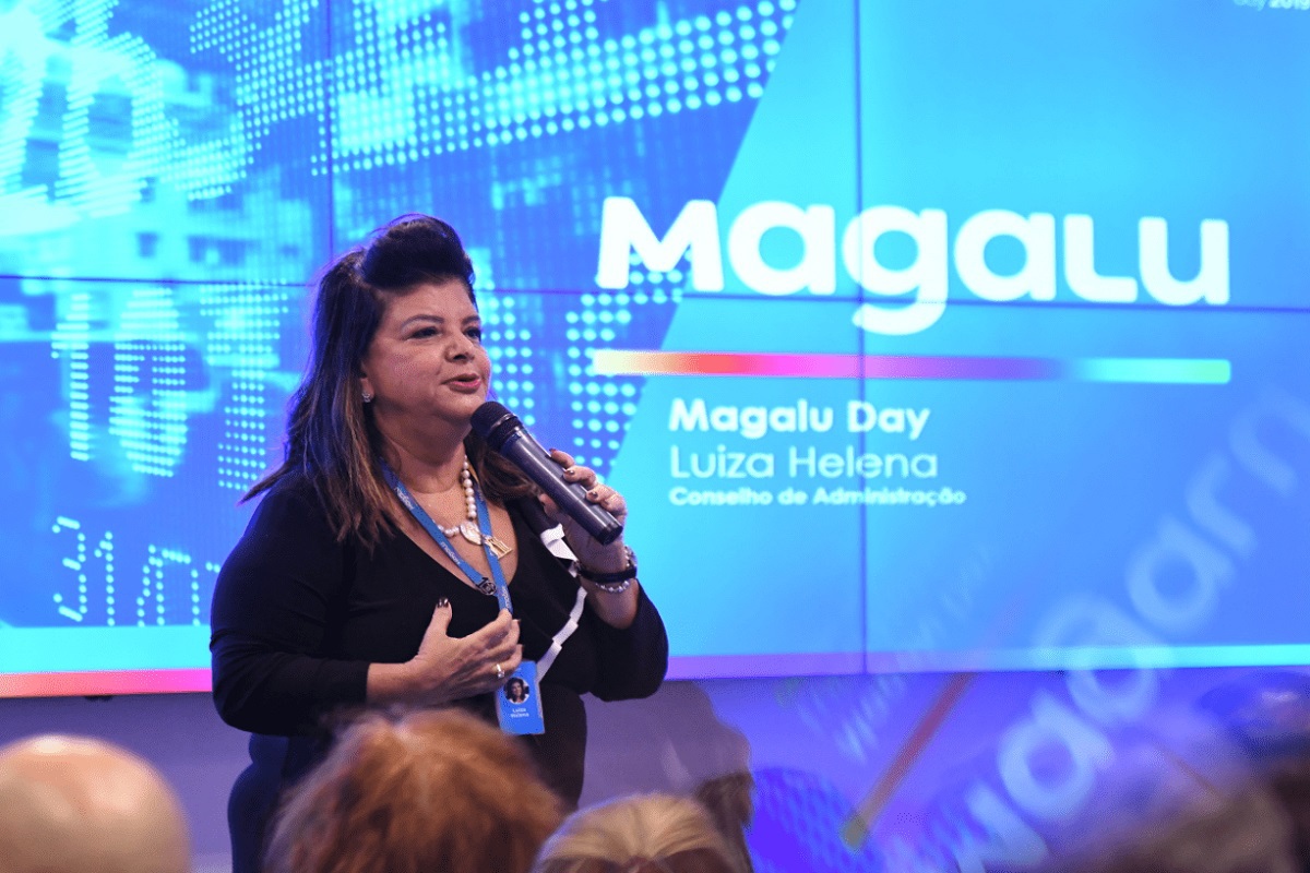 Magalu: Luiza Helena Trajano Luiza Helena Trajano em palestra diante de painel da Magalu