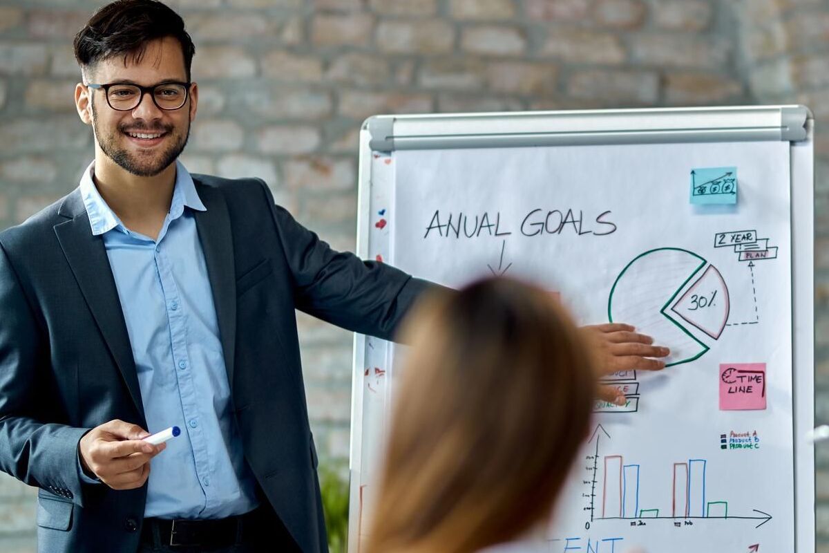 Dados: Matriz Ansoff Homem em reunião com colegas mostrando dados sobre Matriz Ansoff