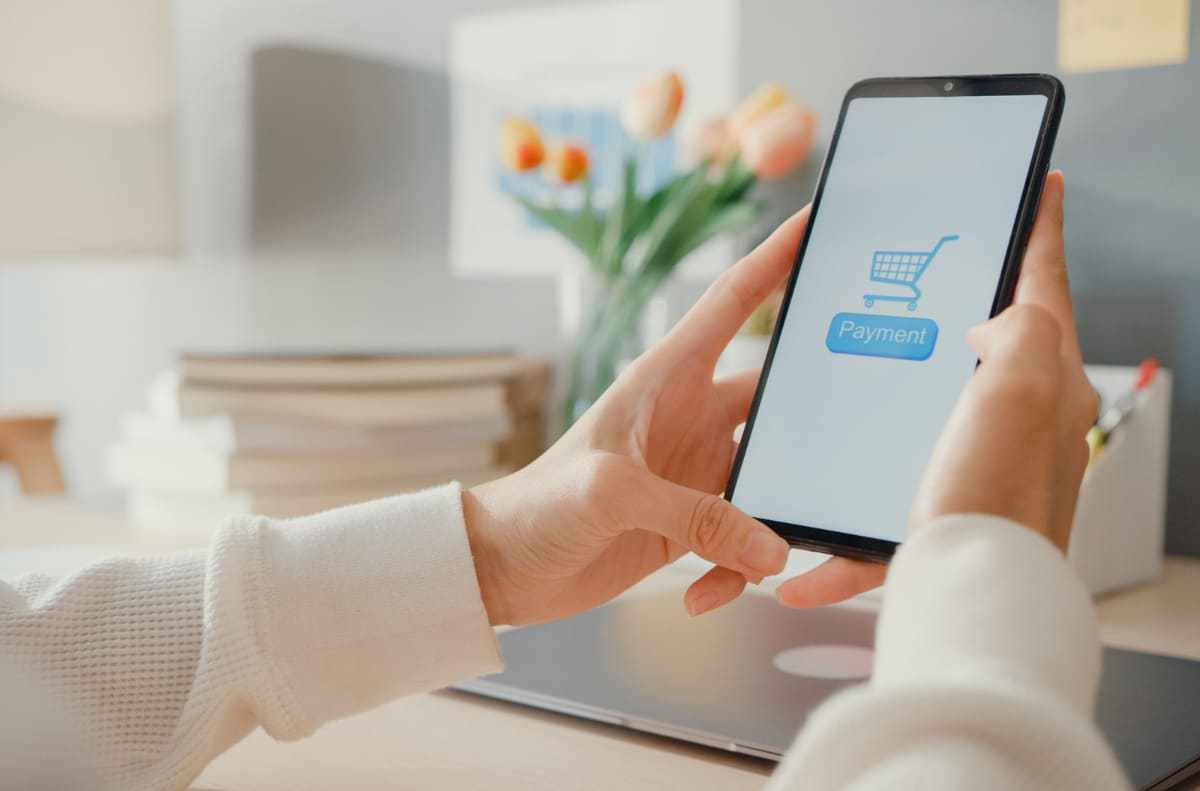 Pessoa com celular na mão para Montar uma loja virtual