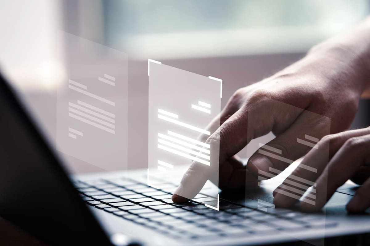 Layout: Nicho para blog Pessoa com notebook digitando algo com holograma de layouts para página web em montagem sobre o teclado do aparelho definindo Nicho para blog