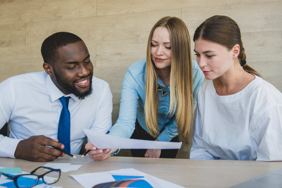 Trabalho: POP Homem ao lado de duas mulheres em local de trabalho aplicando POP ou Procedimento Operacional Padrão