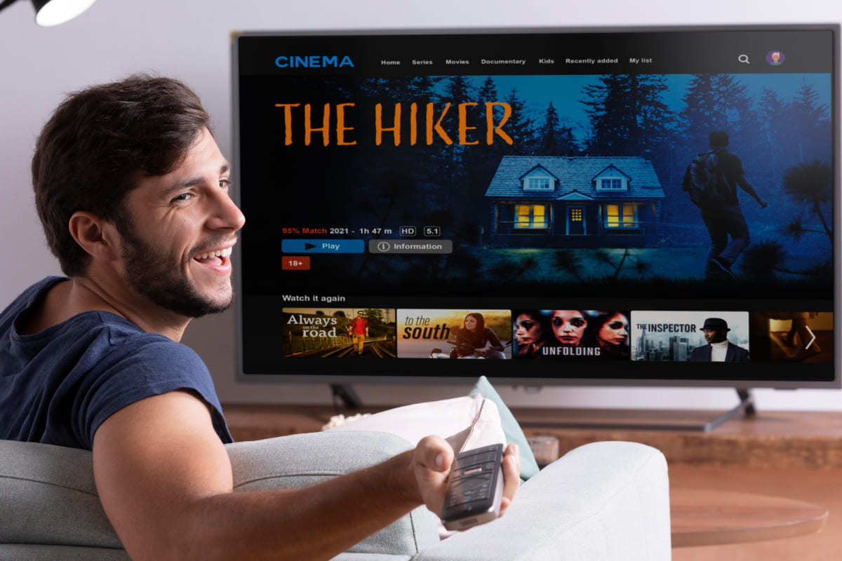 TV: Product placement Homem sorridente sentado diante de smart tv vendo netflix