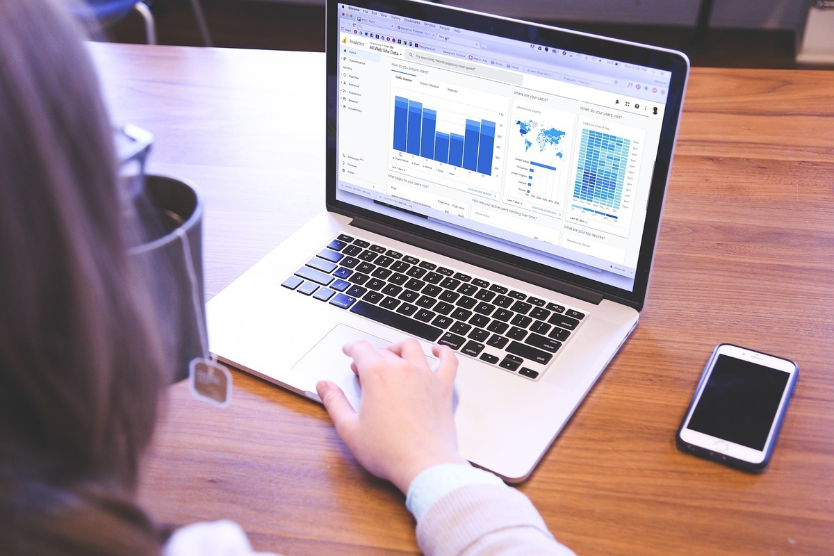 Mulher analisando dados em notebook para Recuperar posições no Google