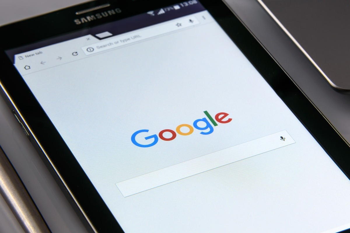 Pessoa usando tablet em pesquisa nos bsucadores para Recuperar posições no Google