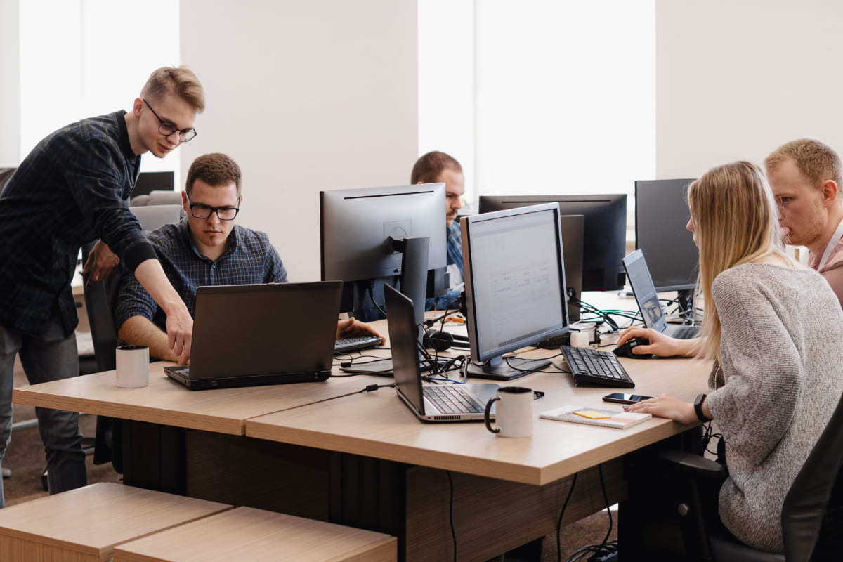 Pessoas em local de trabalho usando computadores com Sistema integrado