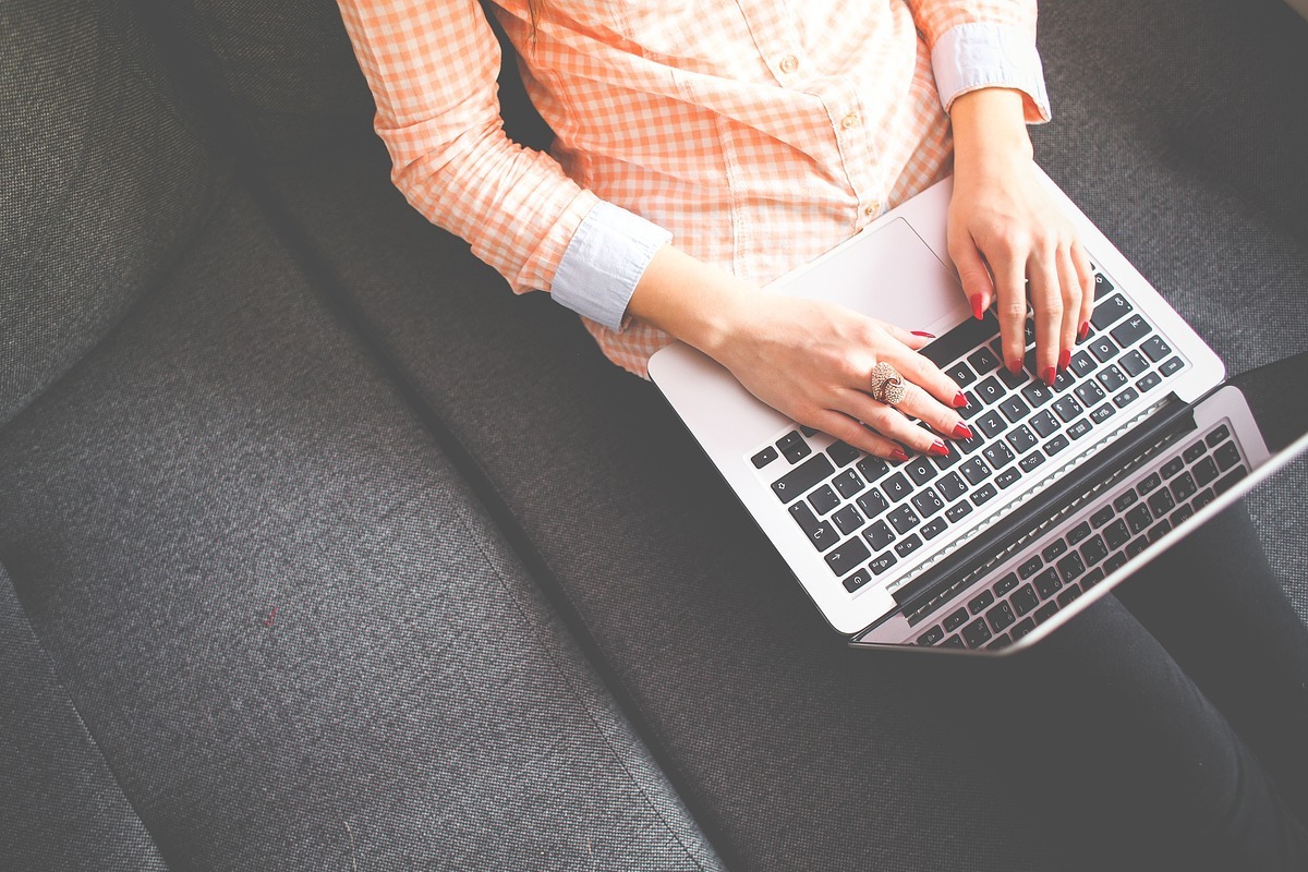 laptop: fazer um blog post mulher sentada com um laptop nas pernas