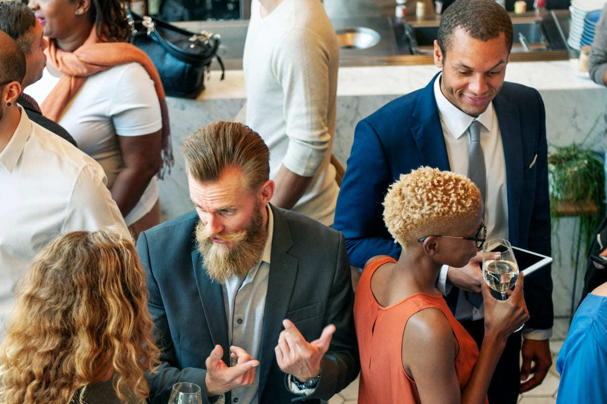 Diálogo: Marketing para eventos Pessoas em diálogo em local movimentado similar à feira que usou Marketing para eventos