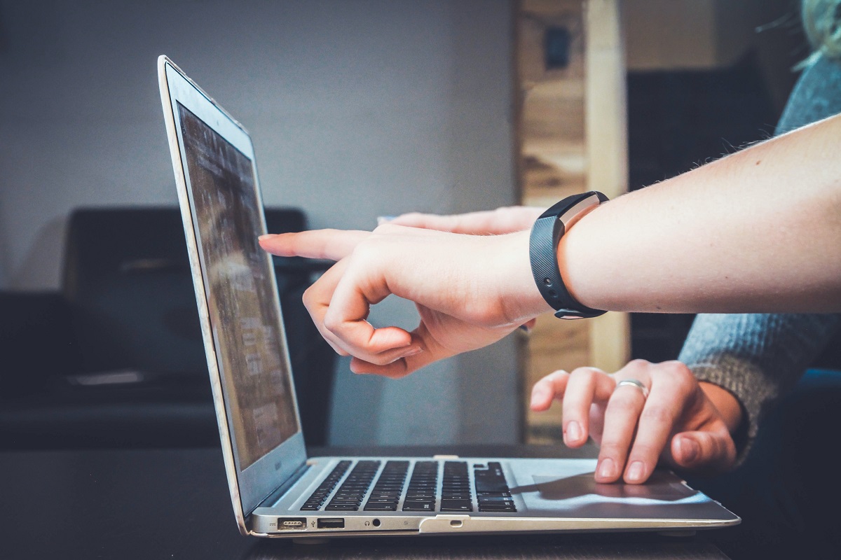 Duas pessoas trabalhando com notebook onde uma delas aponta para algo na tela representando o tema Sidebar para SEO