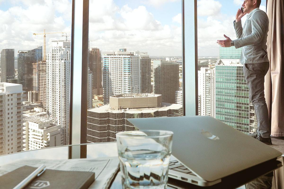 escritório: autoridade online homem conversando olhando para a janela do escritório