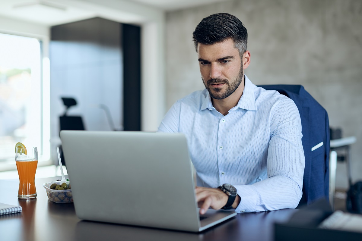 homem sentado, usando o laptop