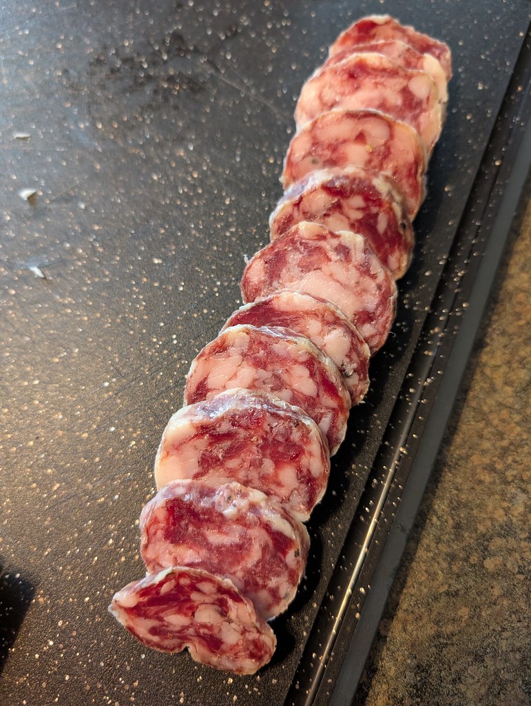 A log of salami that's been sliced up into equal sized rounds. 
