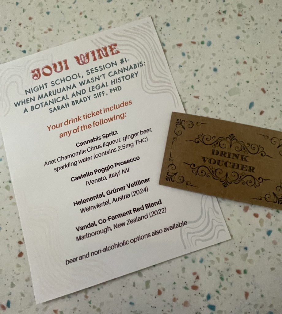 The Joui Wine menu of drinks that can be redeemed with the drink ticket, and the little drink ticket alongside it. The menu is a small piece of white paper, and the drinks available to choose from are 