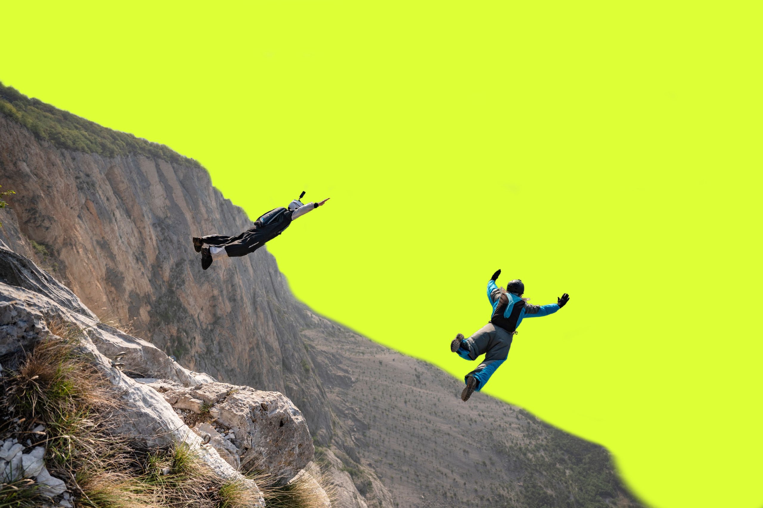 Against a neon green background, two people jump off a cliff wearing parachute packs