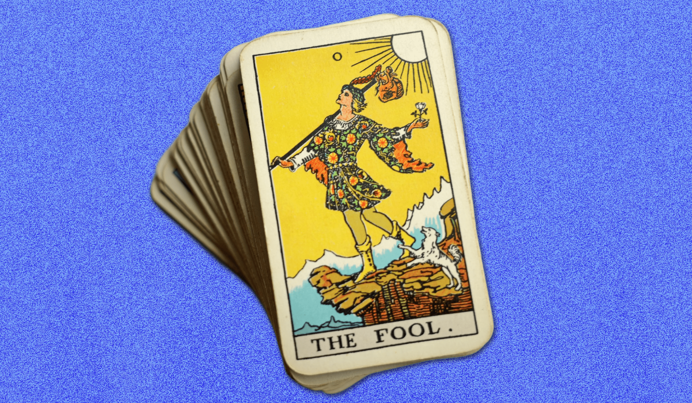 A deck of tarot cards with the fool revealed on top of the stack, against a blue background.