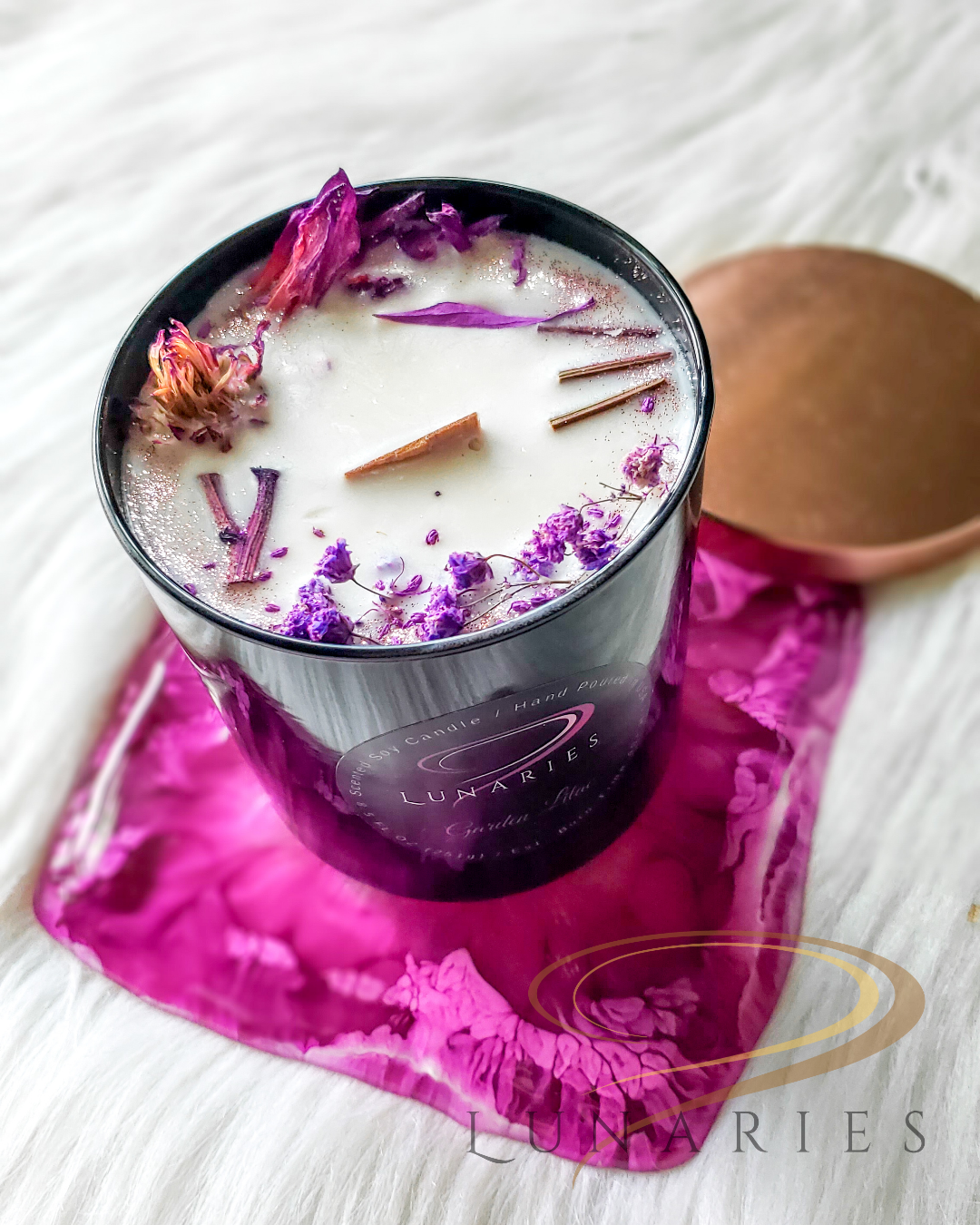 Garden Lilac soy candle in a black glossy tumbler jar, featuring a wooden wick and decorated with vibrant purple botanicals and lilac-inspired purple dried flowers.
